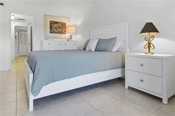 a bedroom with a bed and a painting on the wall