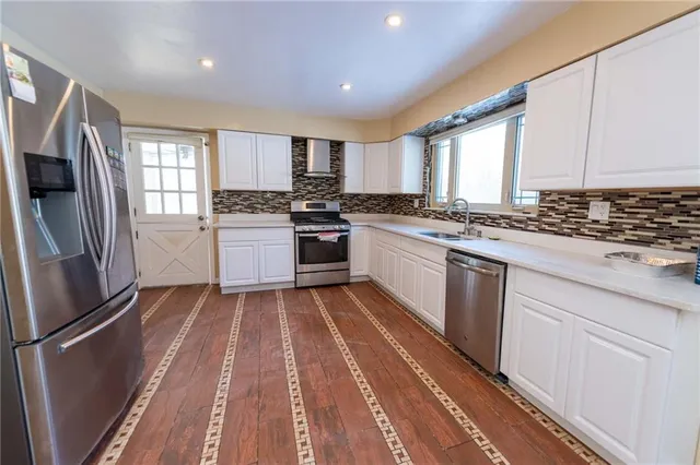 a kitchen with stainless steel appliances granite countertop a stove a sink and a refrigerator