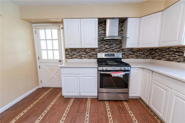 a kitchen with a stove and white cabinets