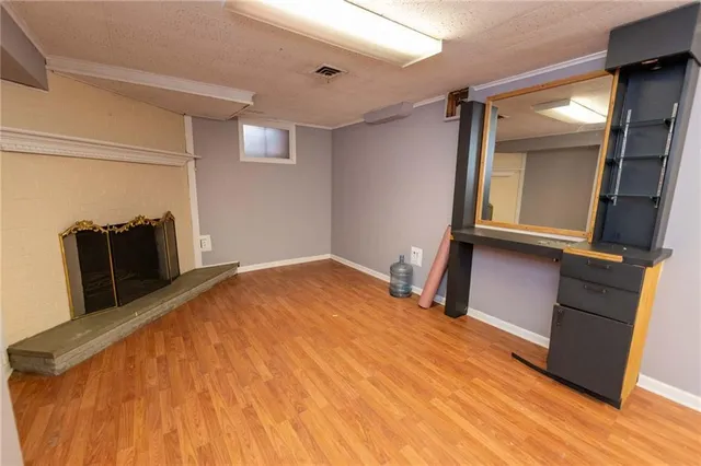a view of empty room with wooden floor and fireplace