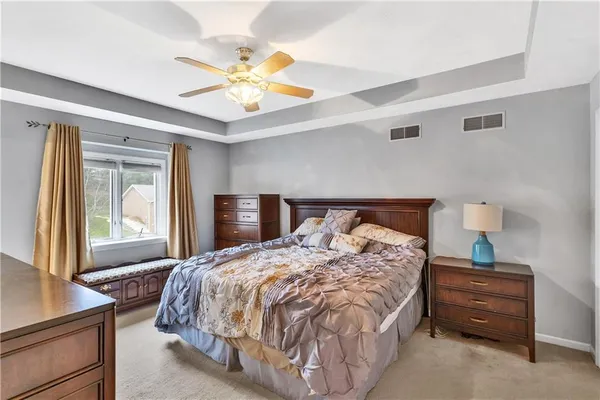 a bedroom with a large bed and a chandelier