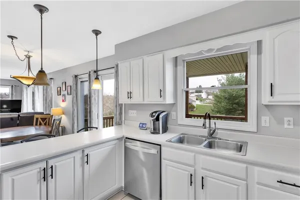a kitchen with stainless steel appliances granite countertop a table chairs and a refrigerator