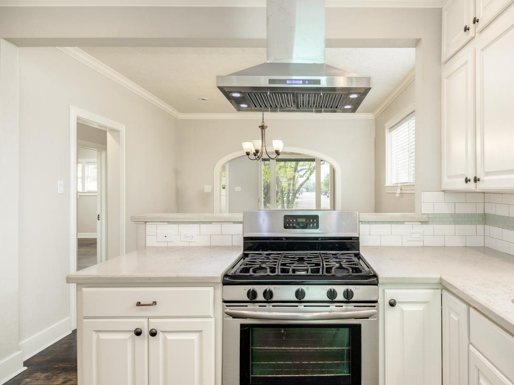 4528 Avenue R 1/2 Galveston, TX 77551 - Photo 13 of 22 a kitchen with a stove a refrigerator and cabinets