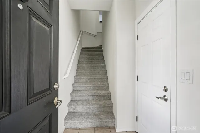 a view of staircase with white walls and white door