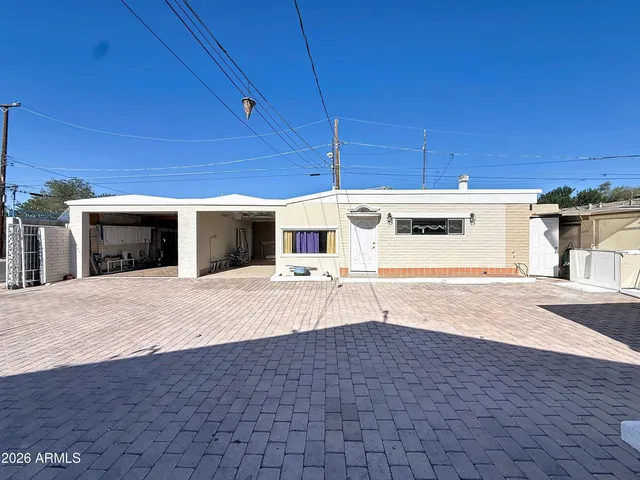 a front view of a house with a yard and potted plants