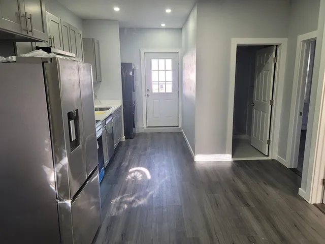a view of a refrigerator in kitchen and wooden floor