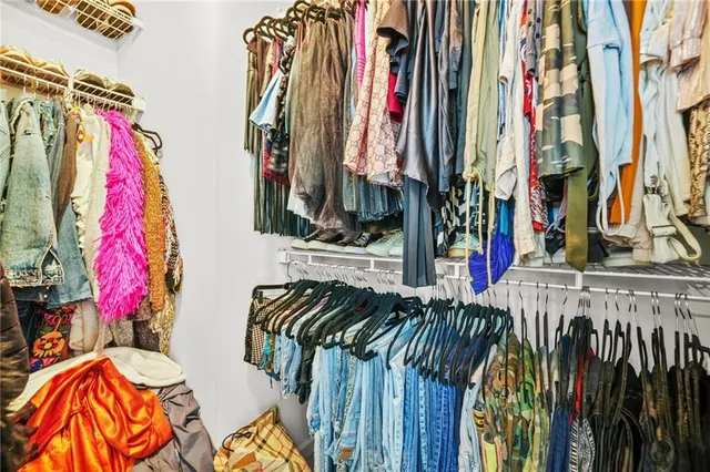 a bedroom with a bed couch painting on the wall and a window