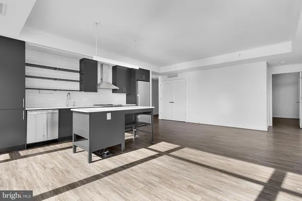 a kitchen with a refrigerator a sink and wooden floor