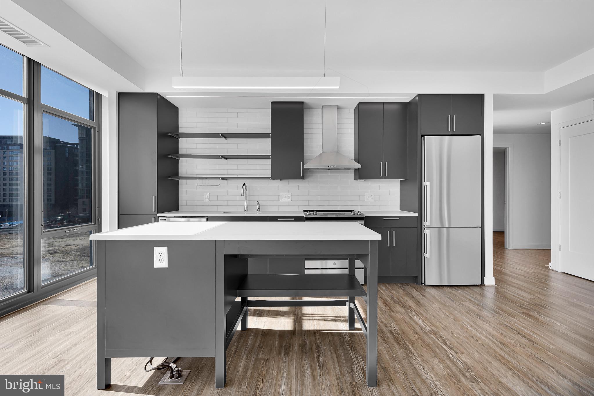 150 I Street Southeast, Unit INTERIOR Washington, DC 20003 - Photo 4 of 21 a kitchen with a refrigerator a sink and wooden floor