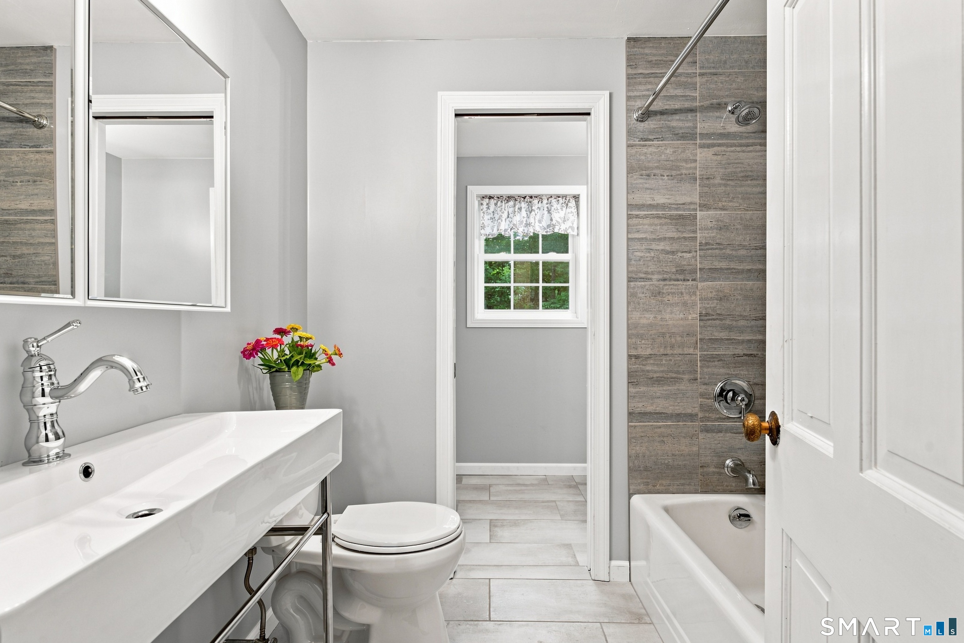 38 Church Lane Madison, CT 06443 - Photo 13 of 40 Fully renovated full bath with pocket door that closes to the primary bedroom.