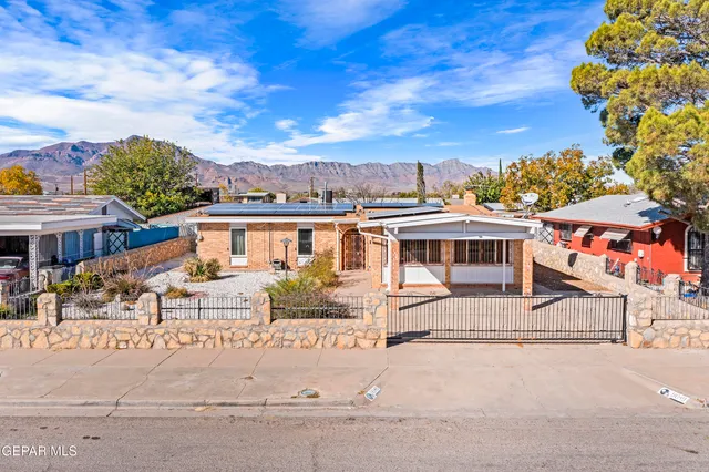 a view of a white building among the street with houses