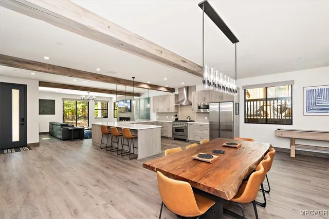 a dining hall with stainless steel appliances kitchen island granite countertop a dining table and chairs with wooden floor