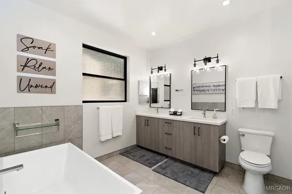a bathroom with a double vanity sink toilet and mirror