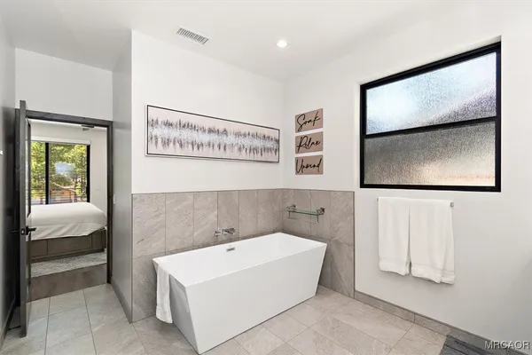 a bathroom with a bathtub and mirror
