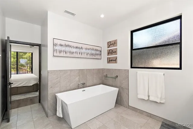 a bathroom with a bathtub and mirror