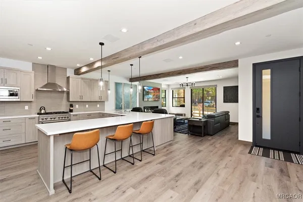 a kitchen with stainless steel appliances kitchen island granite countertop a table chairs sink and cabinets