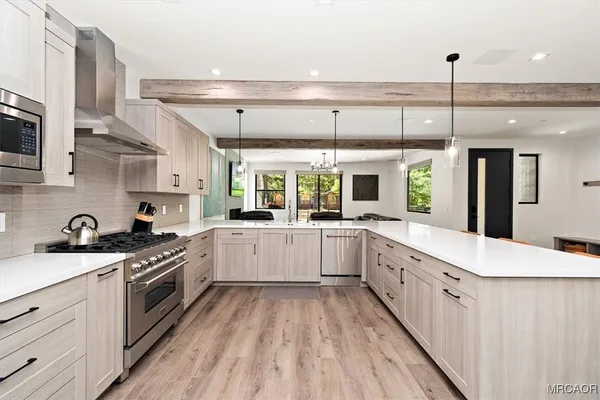 a large kitchen with stainless steel appliances granite countertop a lot of counter space and wooden floors