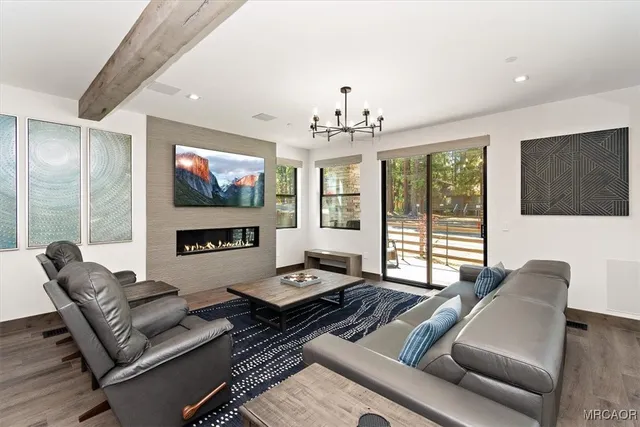 a living room with furniture flat screen tv and a large window