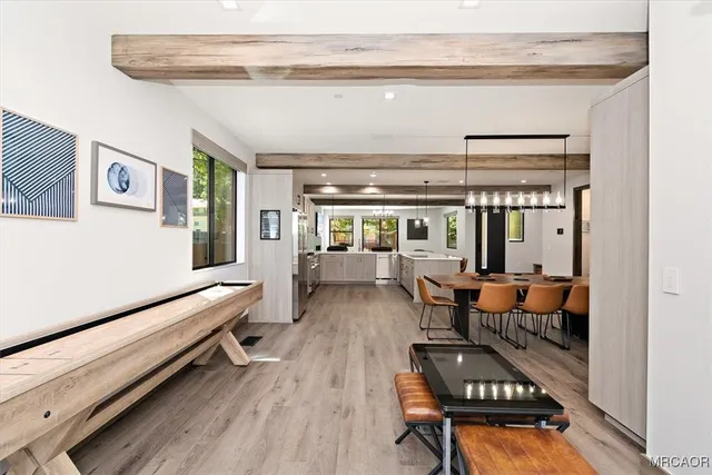 a living room with furniture a dining table and chairs with wooden floor