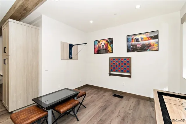 a view of a hallway with wooden floor and a bookshelf