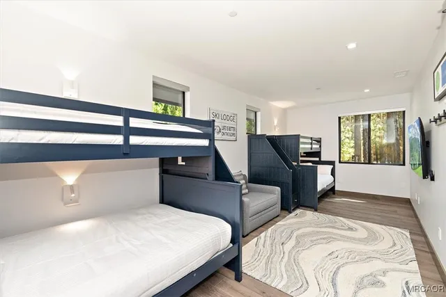 a bedroom with two beds and large windows