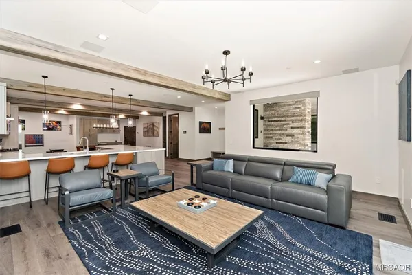 a living room with furniture a rug and a chandelier