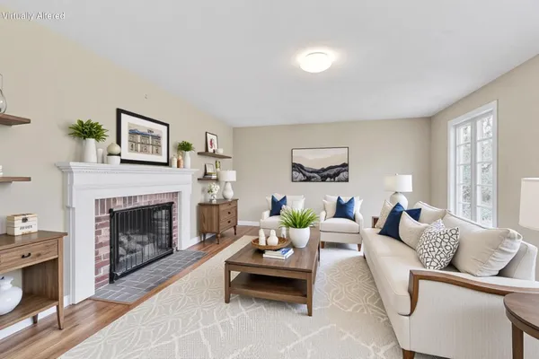 an empty room with wooden floor fireplace and windows