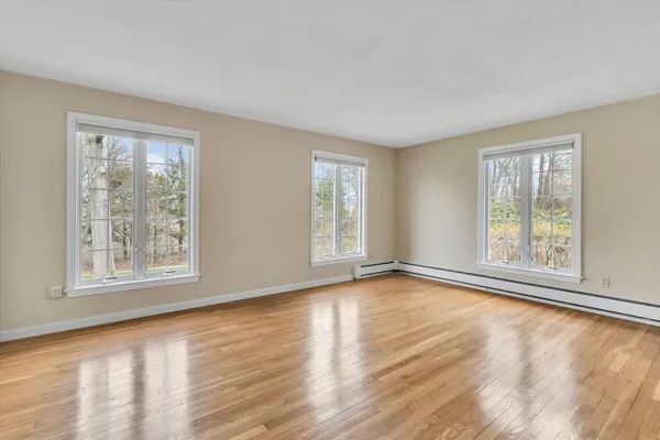 a view of empty room with wooden floor and fireplace
