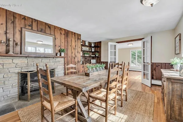 a view of an empty room with wooden floor and a fireplace