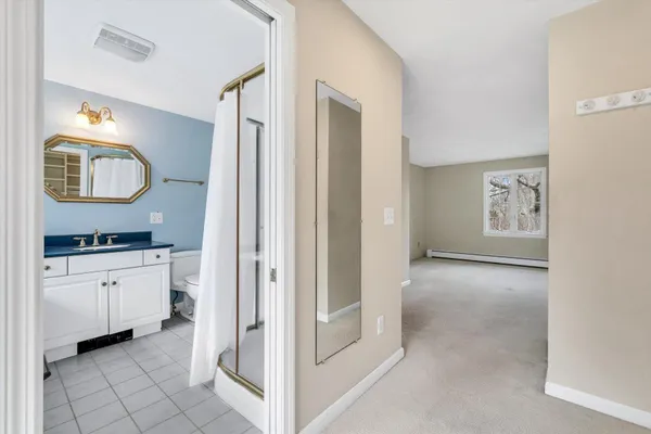 a bedroom with a bed lamp and a large window