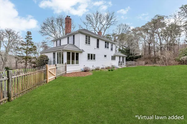 a front view of a house with garden and trees