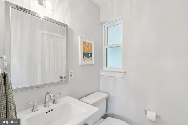 a bathroom with a sink a toilet and mirror