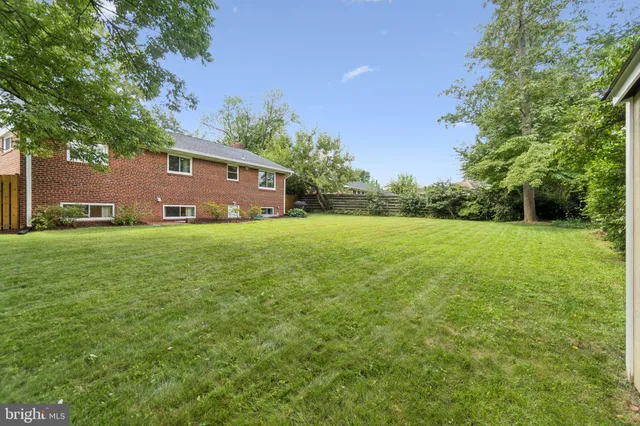 a front view of a house with yard and green space