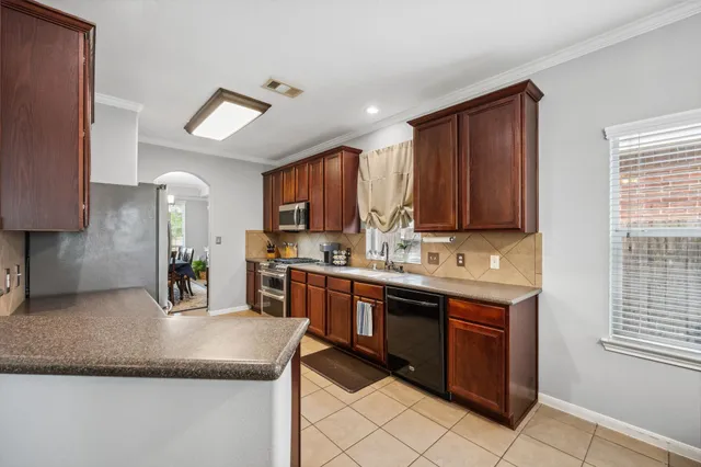 a kitchen with stainless steel appliances granite countertop a sink counter space cabinets and a window