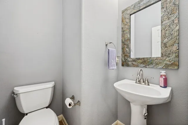 a bathroom with a toilet sink and mirror
