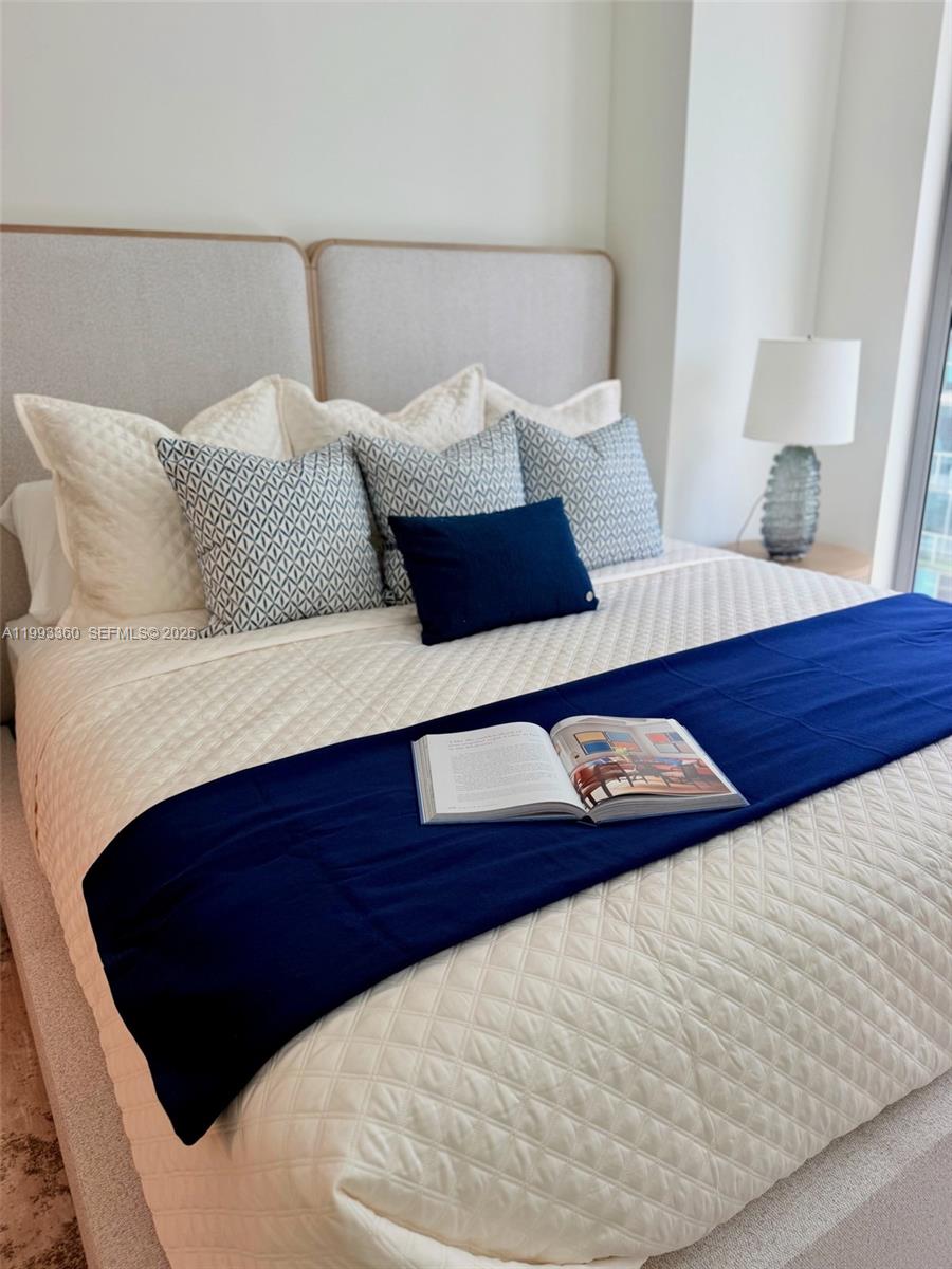 77 Southeast 5th Street, Unit 1608 Miami, FL 33131 - Photo 11 of 44 a bed sitting in a bedroom with a white comforter and pillows