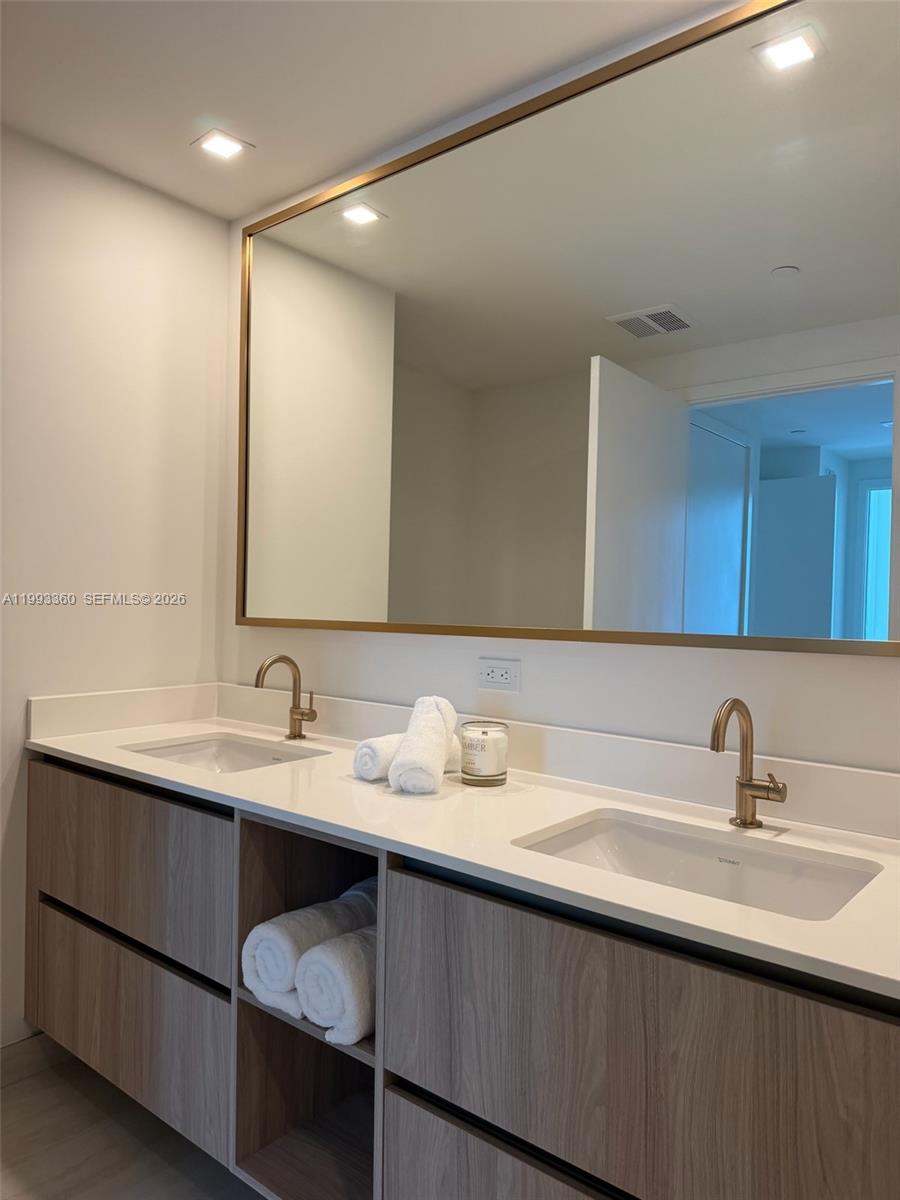 77 Southeast 5th Street, Unit 1608 Miami, FL 33131 - Photo 12 of 44 a bathroom with a double vanity sink and a mirror