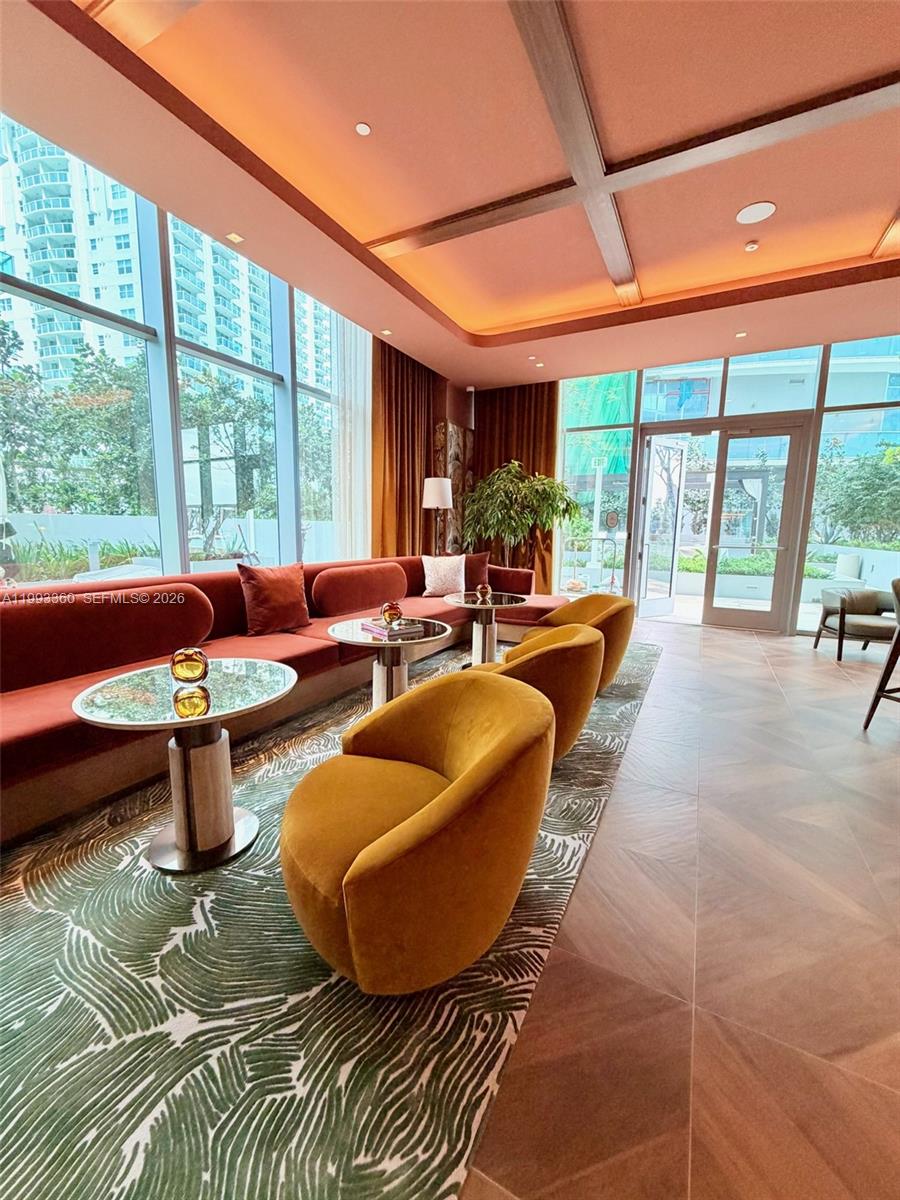 77 Southeast 5th Street, Unit 1608 Miami, FL 33131 - Photo 26 of 44 a living room with furniture and a floor to ceiling window