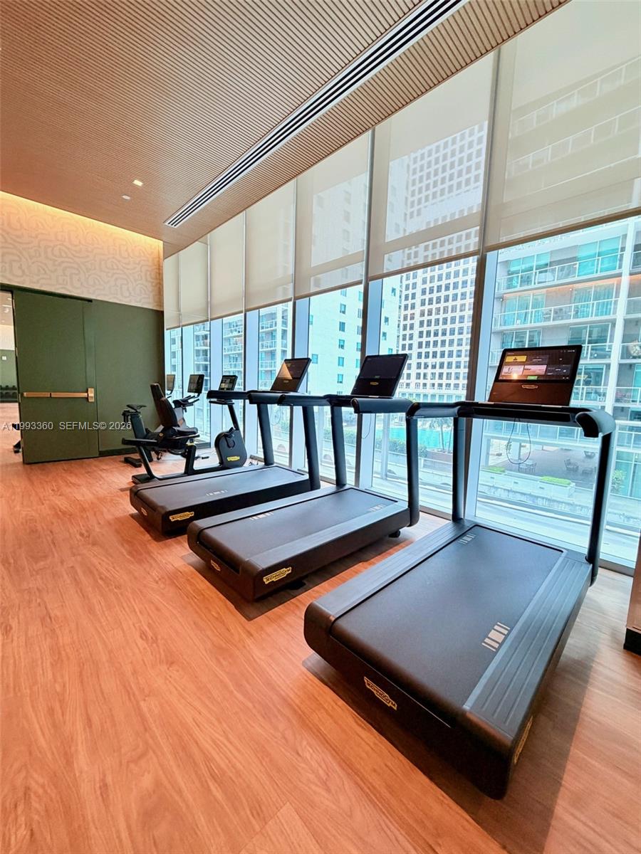77 Southeast 5th Street, Unit 1608 Miami, FL 33131 - Photo 29 of 44 a living room with furniture pool table and a large window