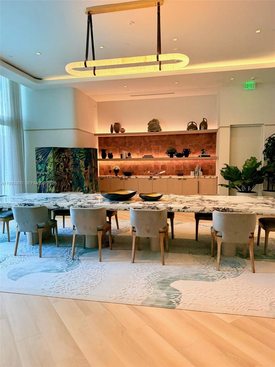 77 Southeast 5th Street, Unit 1608 Miami, FL 33131 - Photo 36 of 44 a view of a swimming pool with a table and chairs