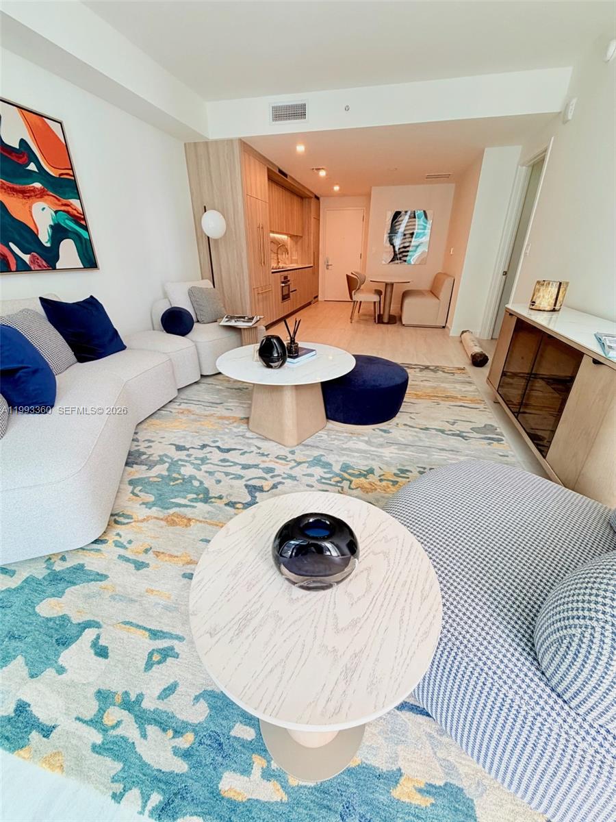 77 Southeast 5th Street, Unit 1608 Miami, FL 33131 - Photo 6 of 44 a kitchen with a sink and a stove with wooden floor