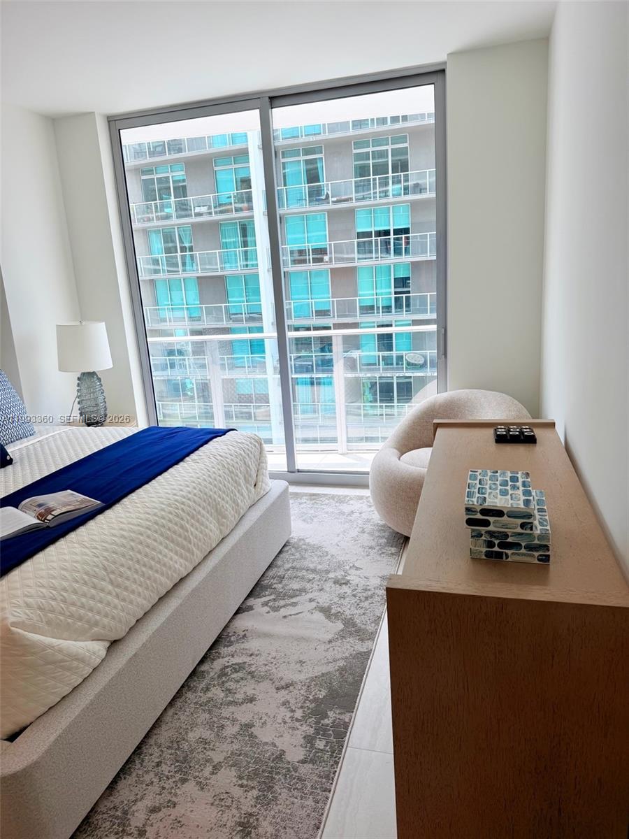 77 Southeast 5th Street, Unit 1608 Miami, FL 33131 - Photo 10 of 44 a bedroom with a bed and wooden floor