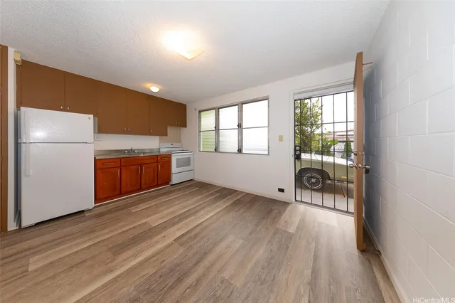 a view of a kitchen with a sink refrigerator and wooden floor