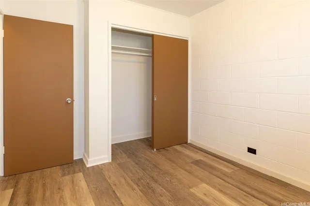 an empty room with wooden floor and closet