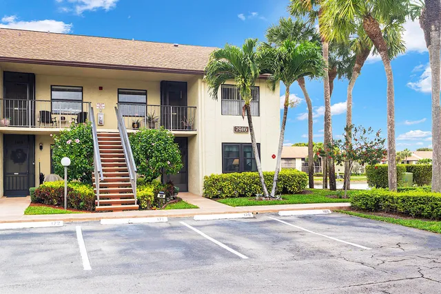 a front view of a house with a yard and potted plants