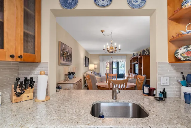a view of a kitchen with kitchen island a sink wooden floor and a large window