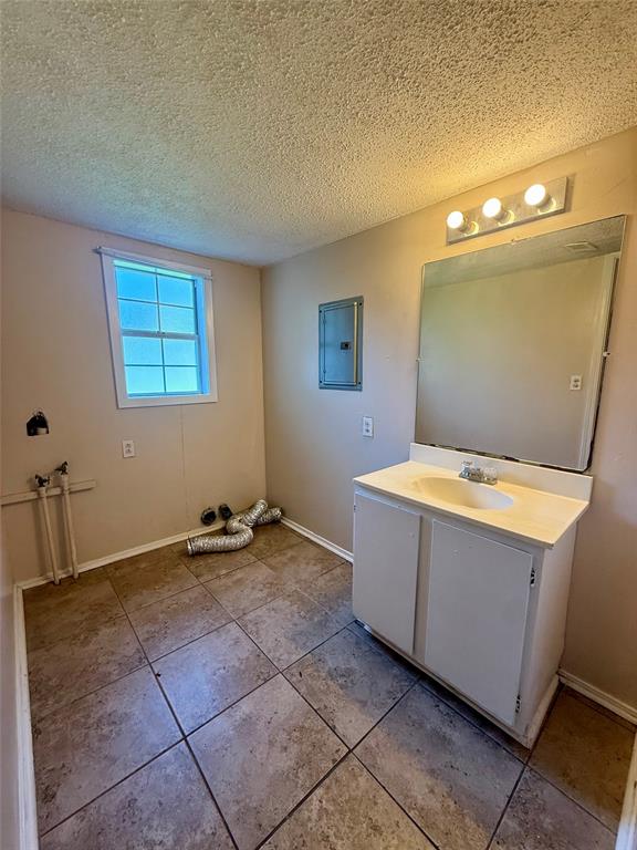 217 3rd St Pinehill Springhill, LA 71075 - Photo 10 of 23 Utility room featuring a single vanity with storage, a wall-mounted mirror, and a 4-bulb light fixture