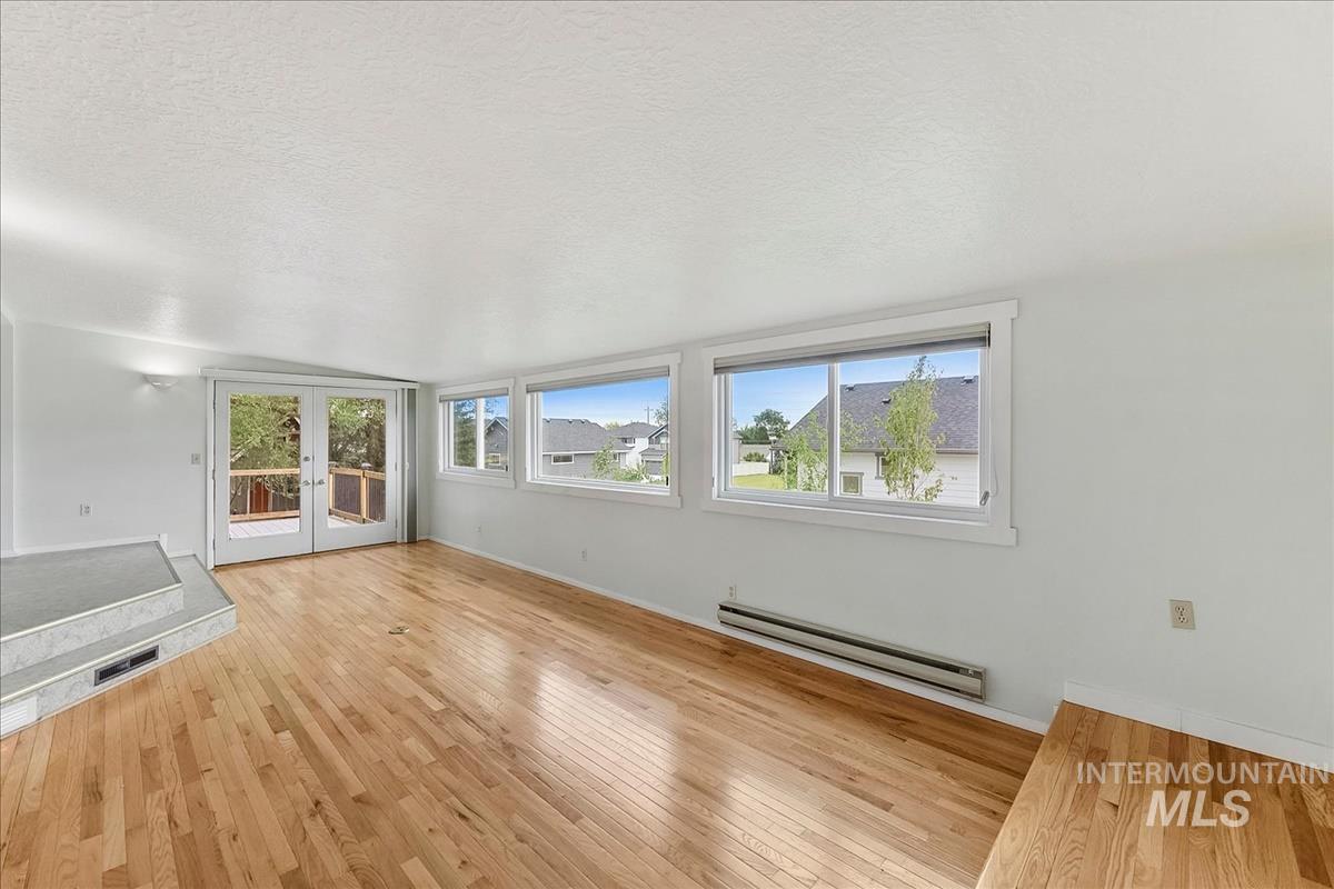 7141 West Hill Road Boise, ID 83714 - Photo 9 of 28 Spacious room featuring light wood-finish flooring, light blue walls, and multiple windows