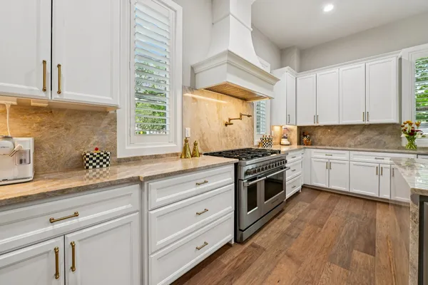 a kitchen with granite countertop white cabinets and white appliances