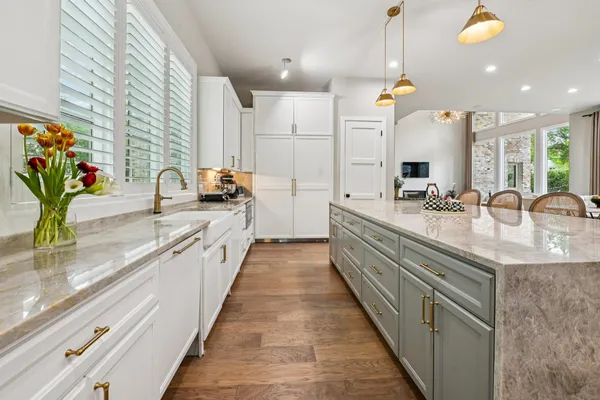 a large kitchen with granite countertop a sink and a counter top space